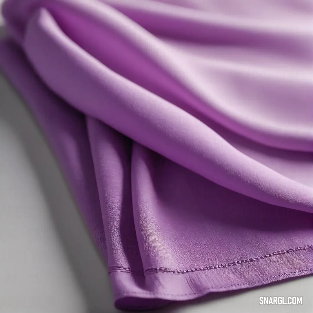 An elegantly folded purple cloth rests gracefully on a pristine white surface, its rich texture inviting touch while embodying a sense of calm and sophistication, expressing both simplicity and beauty in design.