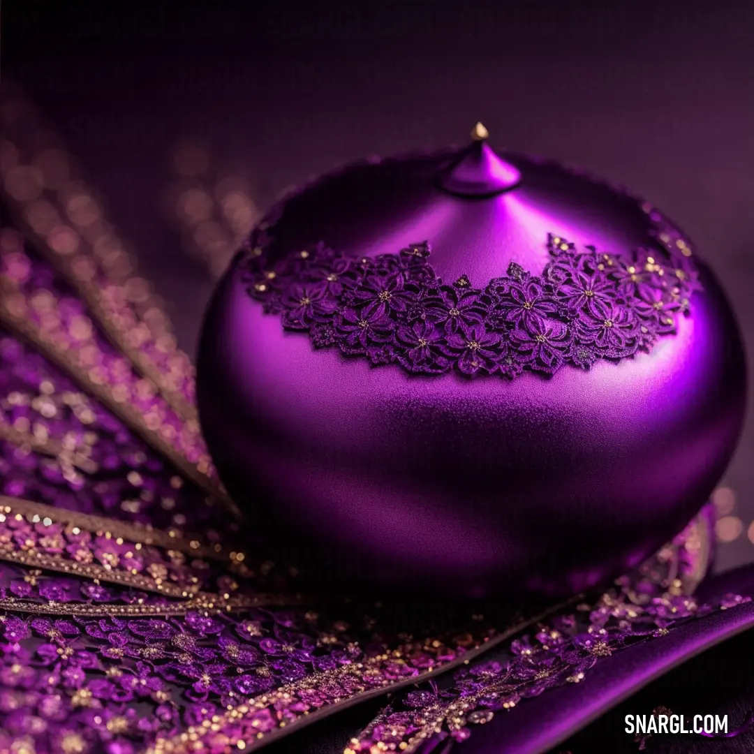 Purple christmas ornament with a purple ribbon on it's side and a purple background. Color #762D6A.