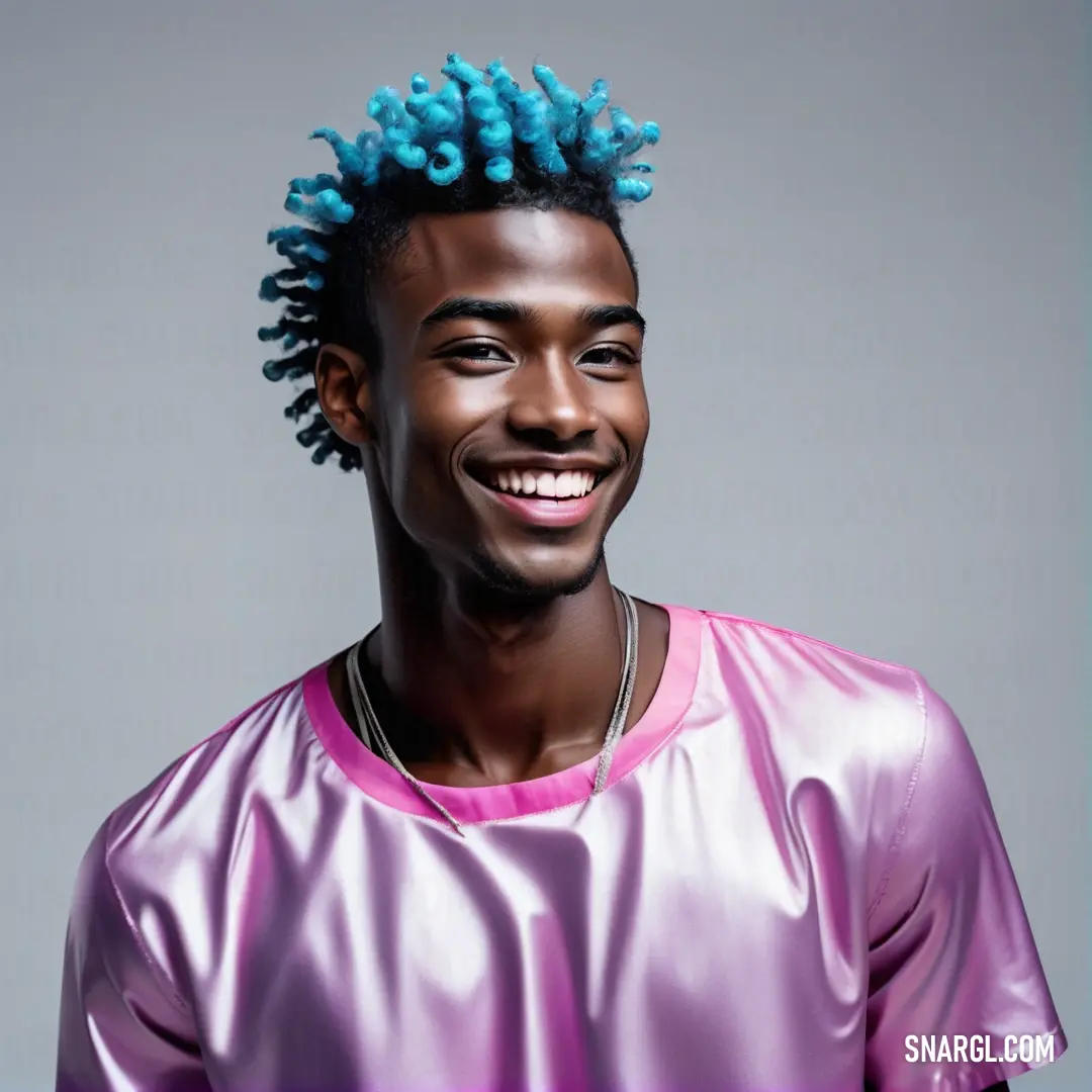 Man with blue hair and a pink shirt smiling at the camera with a smile on his face and a blue mohawk. Color #AD8CBB.