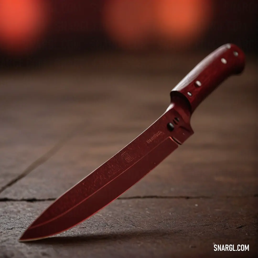 A vibrant red knife lies casually on a rustic wooden surface, while a soft-focus background enhances its striking appearance, capturing the essence of kitchen artistry and practicality in one image.