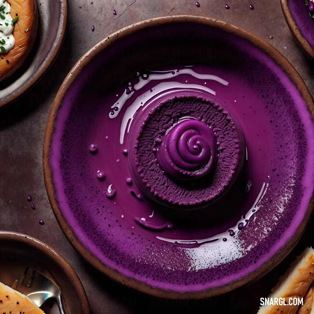 Purple plate with a spiral design on it and other plates with food on it and a spoon in the middle. Color RGB 128,45,130.