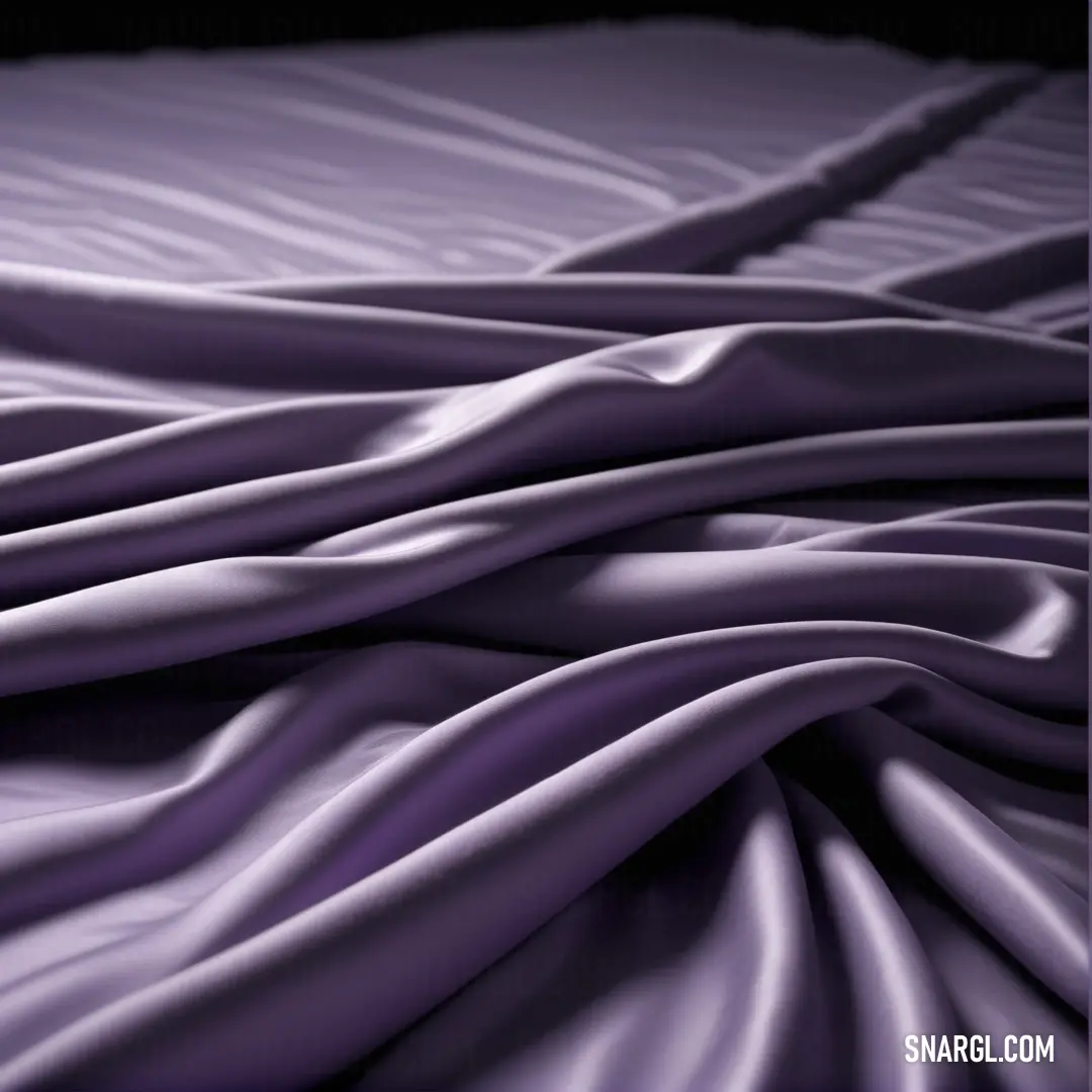 A bed adorned with a rich purple comforter, set against a dramatic black background that highlights the deep, bold hue of the bedding.