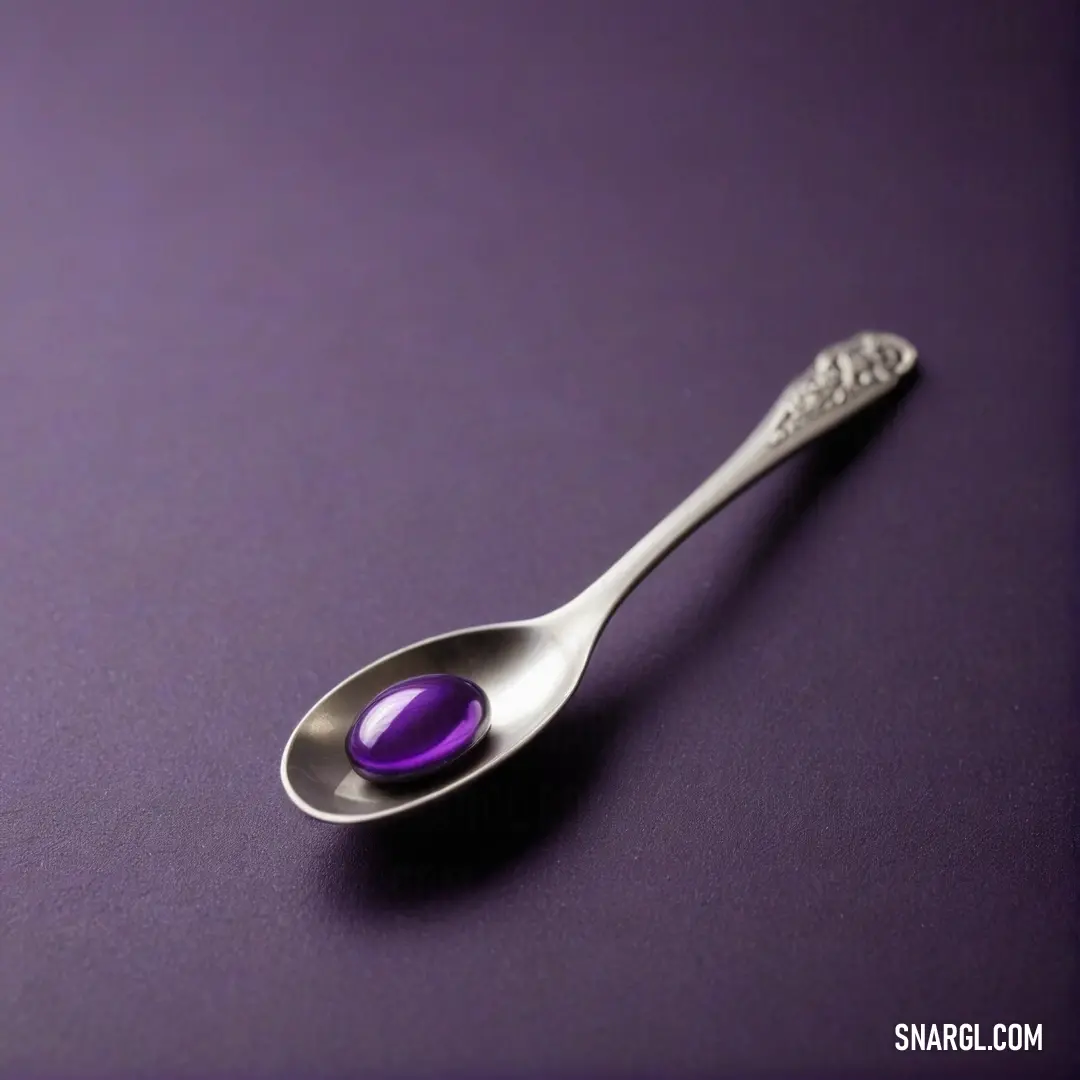 A beautifully arranged spoon enhancing a dazzling purple stone resting gracefully upon it, showcasing a mesmerizing color on an equally stunning purple surface that adds depth to the scene.