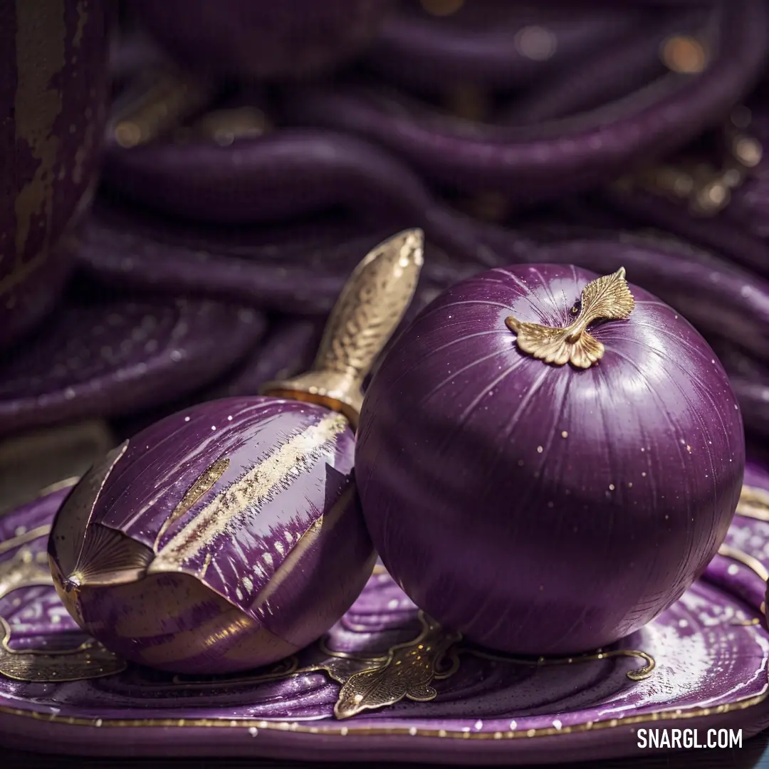 Purple onion on top of a purple plate next to a purple bowl and a gold spoon on a purple plate. Example of CMYK 75,100,8,26 color.