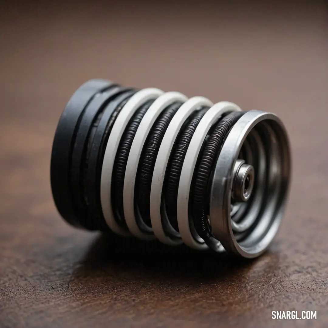 A striking close-up of a metallic object proudly rests on a table, featuring a rich brown surface and bold black and white stripes. The detailed texture adds depth and character, capturing attention effortlessly.