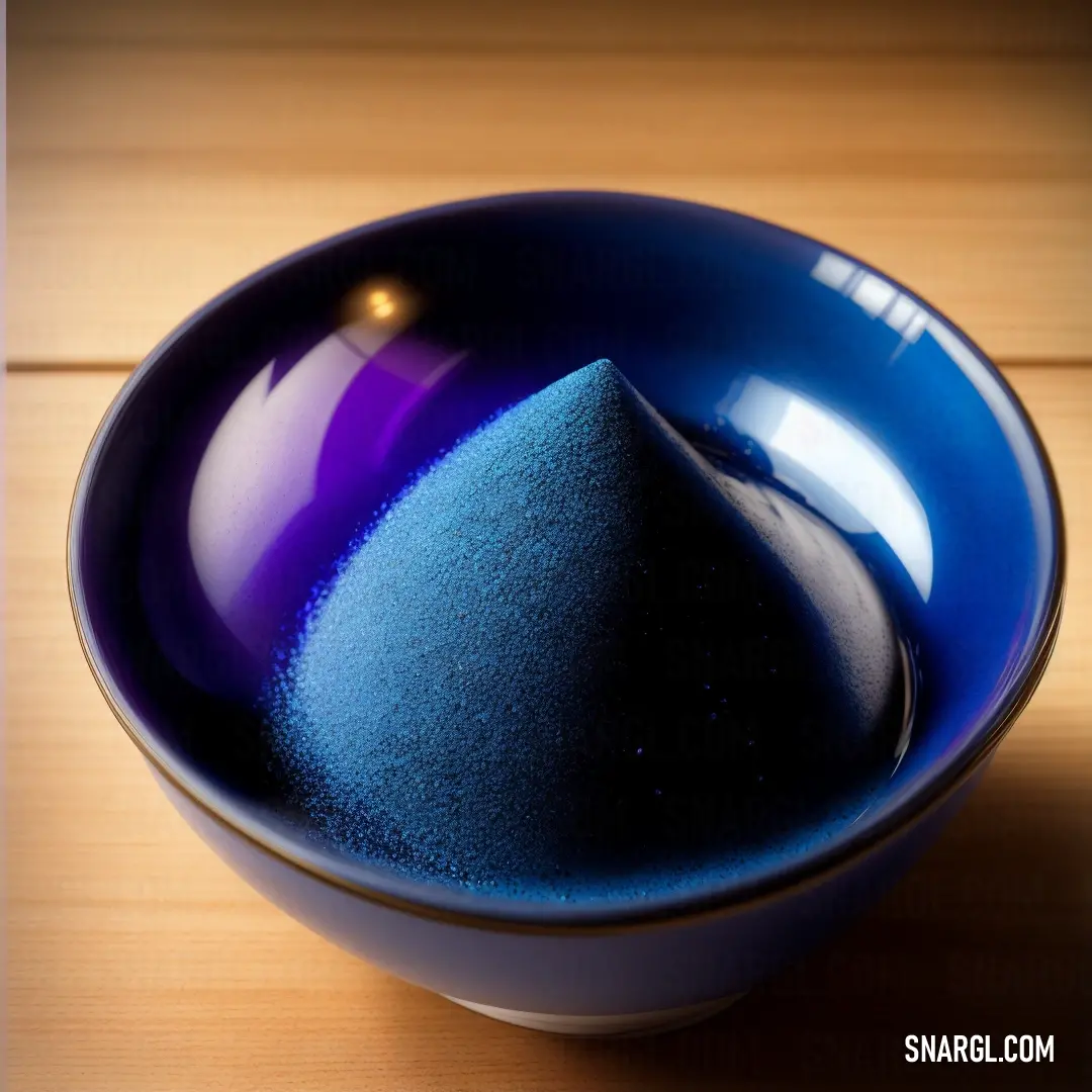 Blue bowl with a blue substance in it on a wooden table top with a light brown background. Example of PANTONE 288 color.