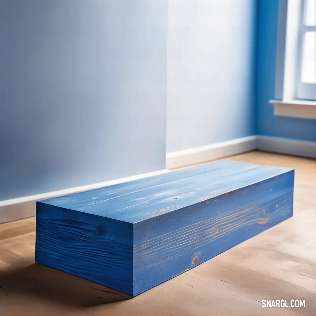 A cozy blue bench positioned near a sunlit window, contrasting beautifully with the blue wall that envelops it. The harmonious shades create a serene atmosphere, perfect for relaxing or daydreaming.