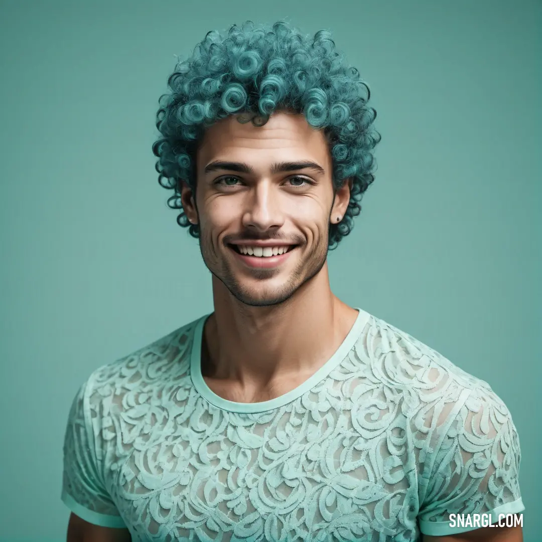 Man with a blue curly hair smiling at the camera with a green background. Example of CMYK 34,0,6,0 color.