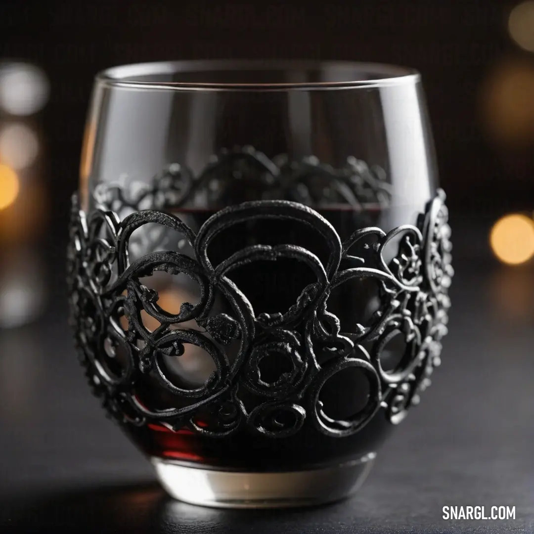 A stylish glass of wine, donned with a chic black design, stands proudly amid an ambient setting with a candle holder in the background. This composition captures the essence of sophistication, creating an inviting atmosphere for leisurely evenings.