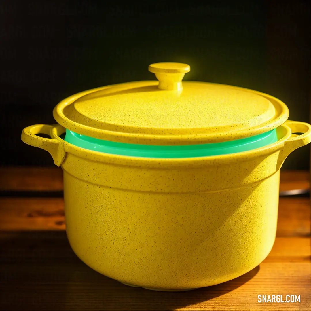 Yellow pot with a lid on a wooden table with a bottle of wine in the background. Color PANTONE 396.