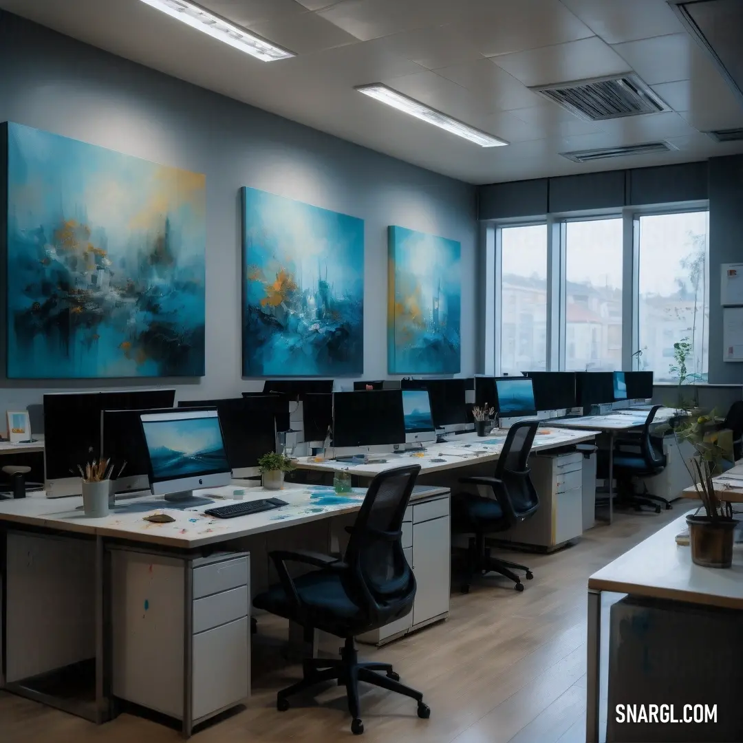 Room with a lot of desks and computers on it and paintings on the wall behind them and a window. Example of PANTONE 406 color.