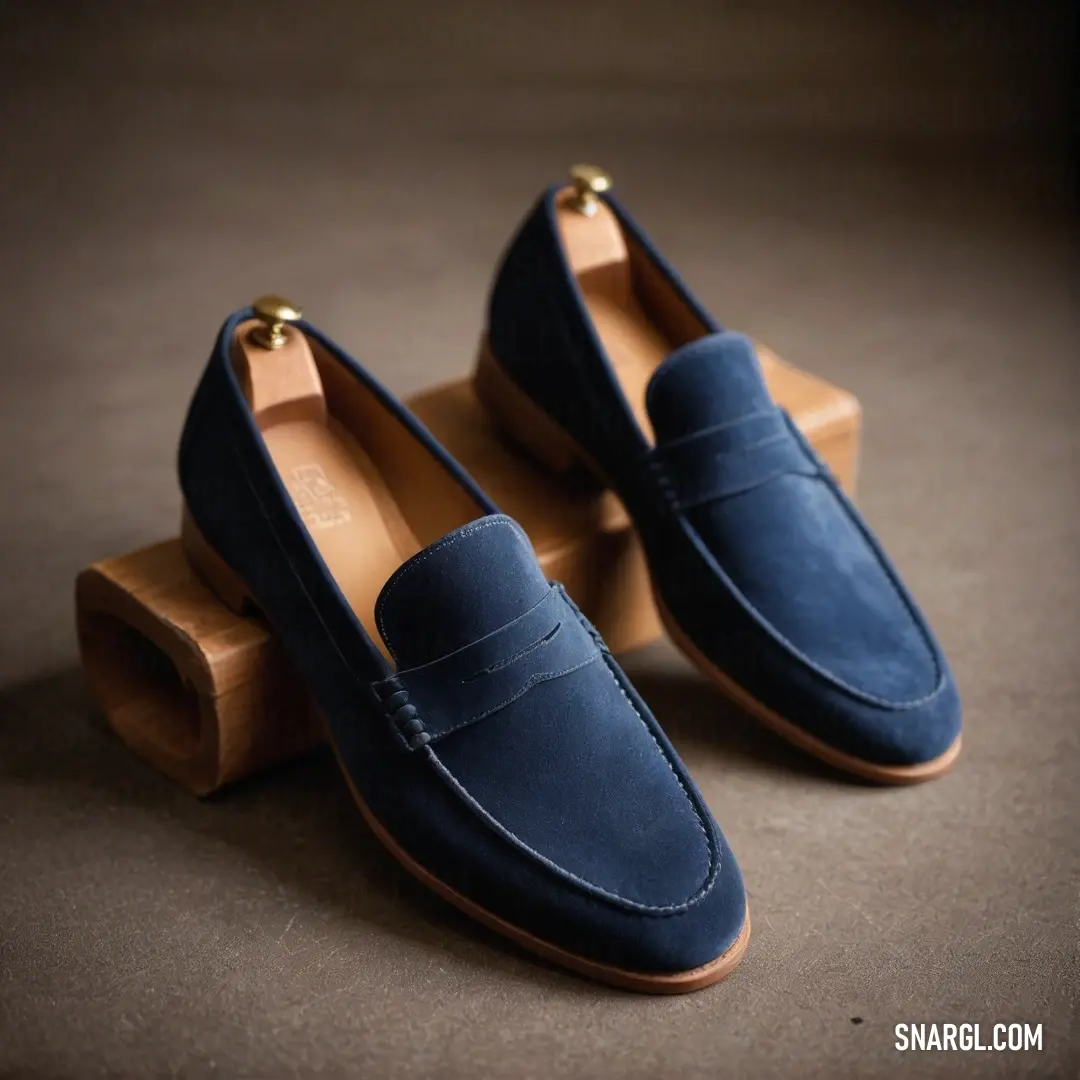 A pair of stylish blue loafers catch the eye, resting atop a warm floor. Next to them lies a wooden block, complementing the footwear's design with earthy, versatile tones that invite casual elegance into any room.