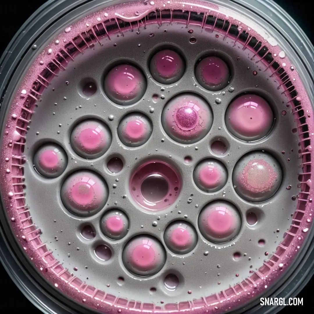 Close up of a pink and white object with bubbles on it's surface and a black background. Color #D497B0.