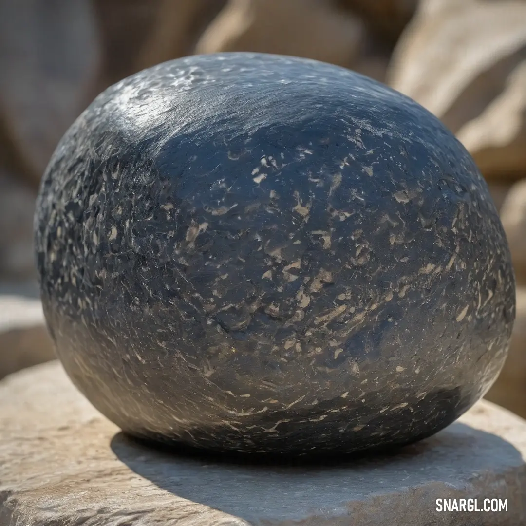 A rugged rock showcases a mysterious black substance, resting on a textured surface surrounded by additional rocks, evoking intrigue about natural formations and their untold stories.