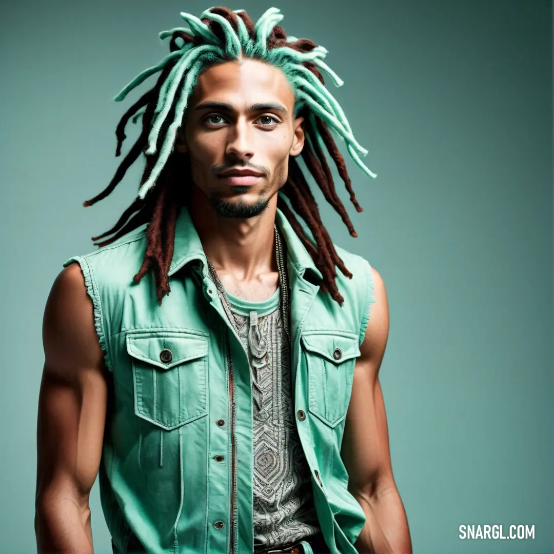 Man with dreadlocks standing in front of a blue background wearing a green shirt and jeans jacket. Example of RGB 130,198,176 color.