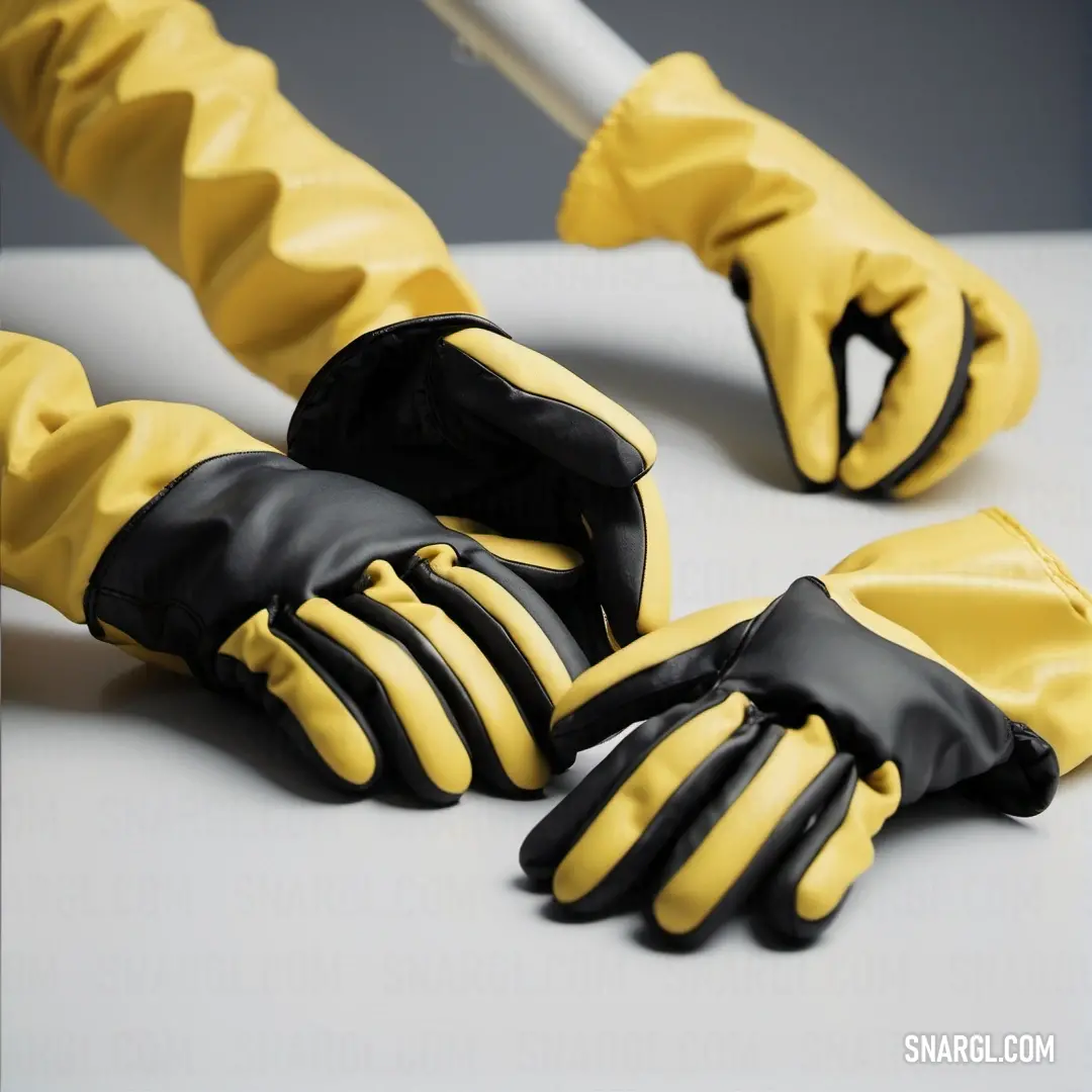 A vibrant duo of yellow and black gloves rests casually on a pristine white tablecloth, evoking a sense of utility and style. The CMYK values of 5,0,55,0 reflect the bold appearance of these everyday essentials, ready for any task.