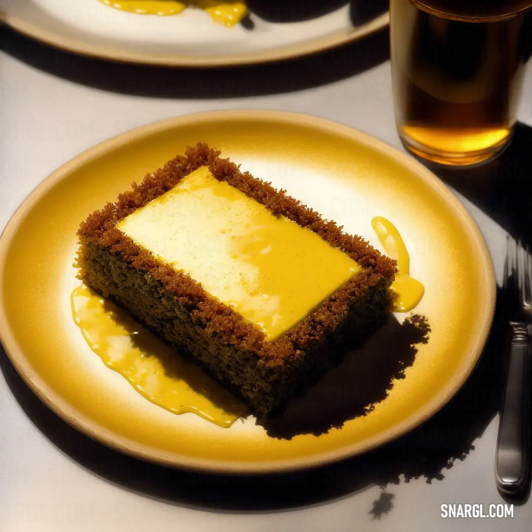 Piece of cake on a plate with a fork and a glass of beer in the background on a table. Color CMYK 0,31,100,0.