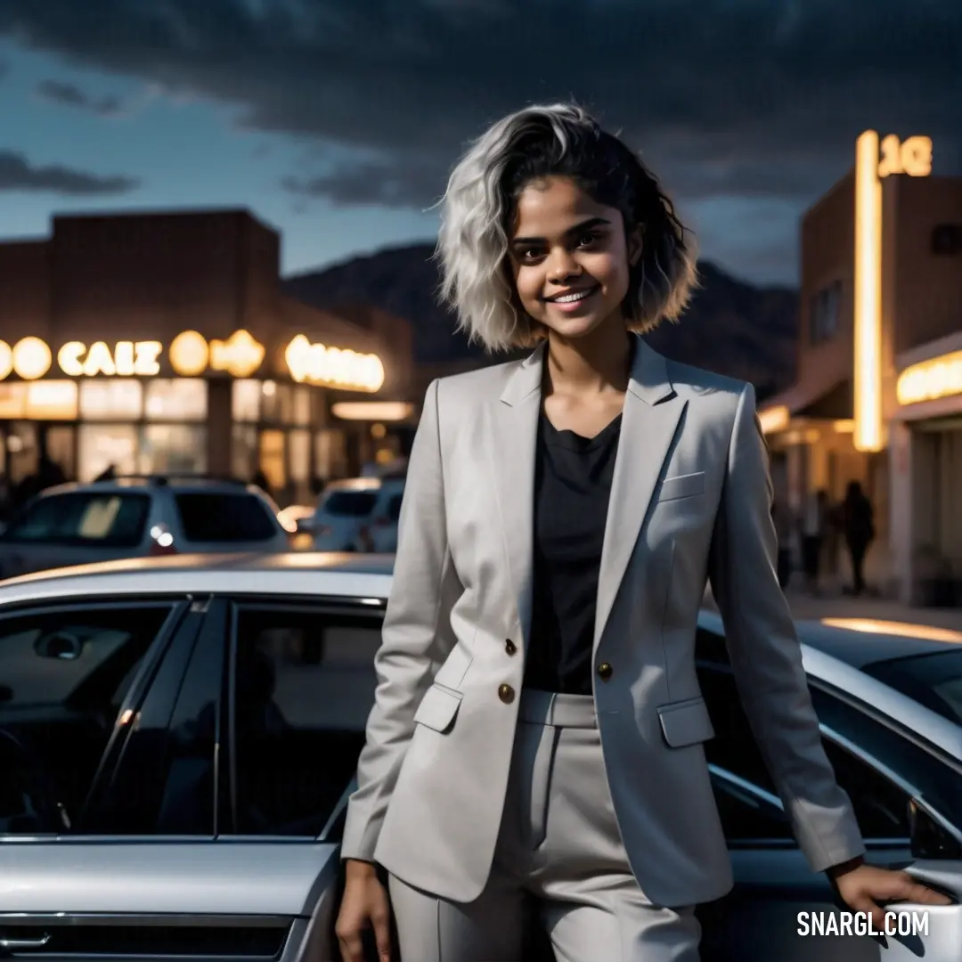 Woman standing next to a car in a parking lot at night with a cloudy sky in the background. Example of PANTONE 7444 color.