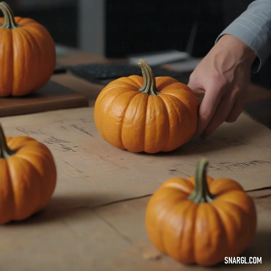 In a heartwarming scene, a person meticulously carves a pumpkin on a table, surrounded by a vibrant array of pumpkins. A keyboard rests nearby, hinting at the blend of tradition and technology as the autumnal colors offer a reminder of seasonal joy.