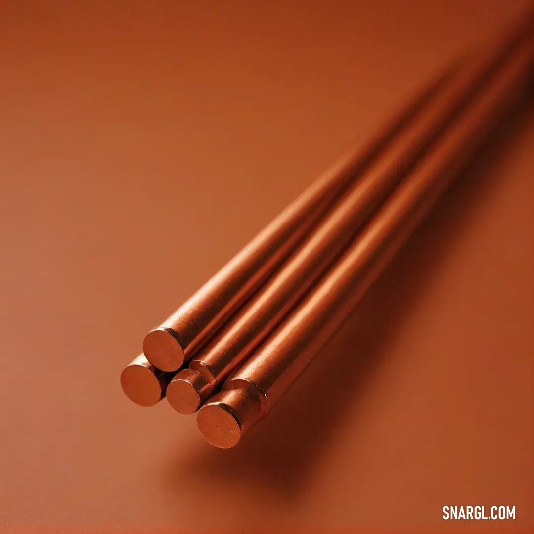 An array of copper-colored rods artistically arranged on a warm brown surface, embodying a rich color palette that adds warmth and style to any setting.