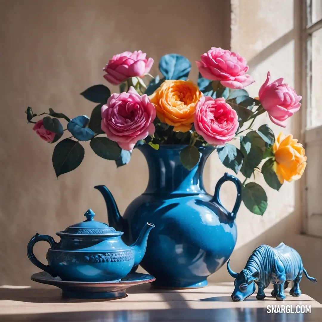 A charming tabletop scene featuring a beautiful blue vase adorned with fresh flowers, a shiny teapot, and a playful small elephant figurine, all harmoniously arranged to create a welcoming vibe in the space.