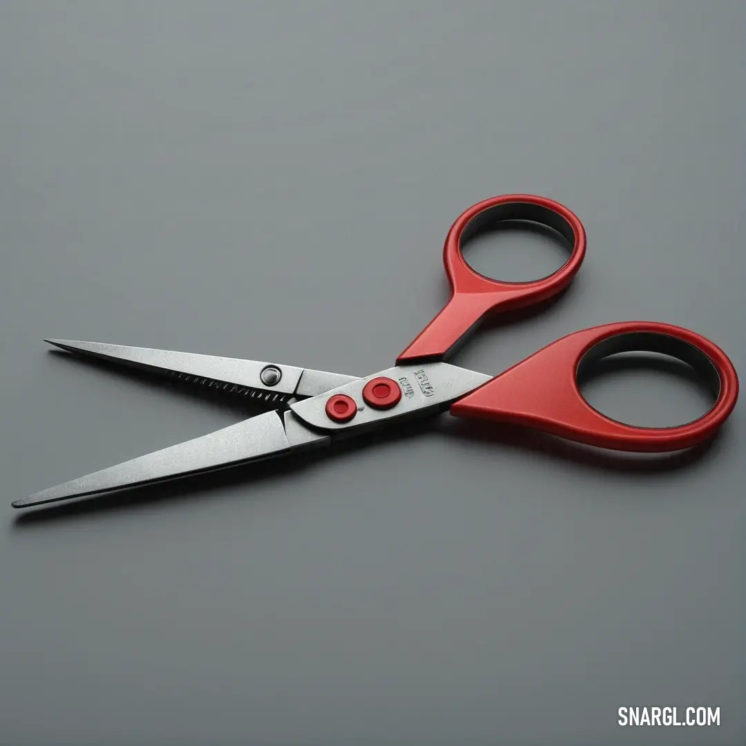 A pair of striking red scissors rests on a minimalist gray surface, the bold black handle intertwining seamlessly with the PANTONE Red 032 blades, exemplifying both utility and an eye-catching design.