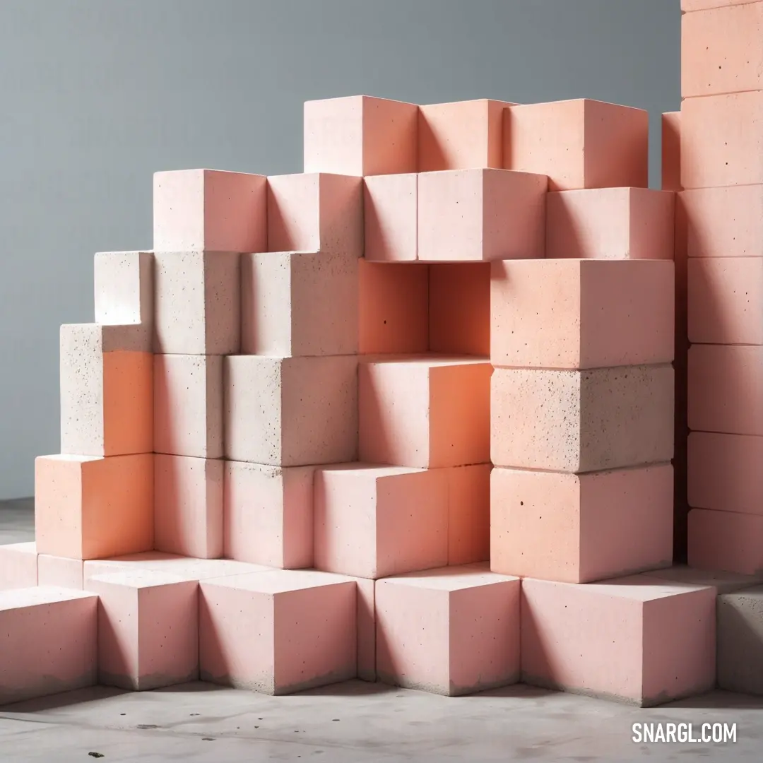 A vibrant pile of pink blocks rests on a floor near a wall of cement blocks under a gray background. The colorful arrangement provides a whimsical touch to the industrial setting, effectively showcasing the playful side of construction materials and desig