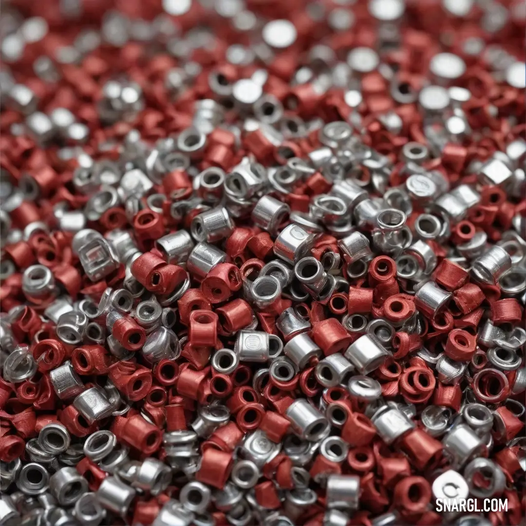 A stunning array of red and silver beads rests elegantly on a table, with a calming blue background enhancing their rich colors and textures in a delightful arrangement.