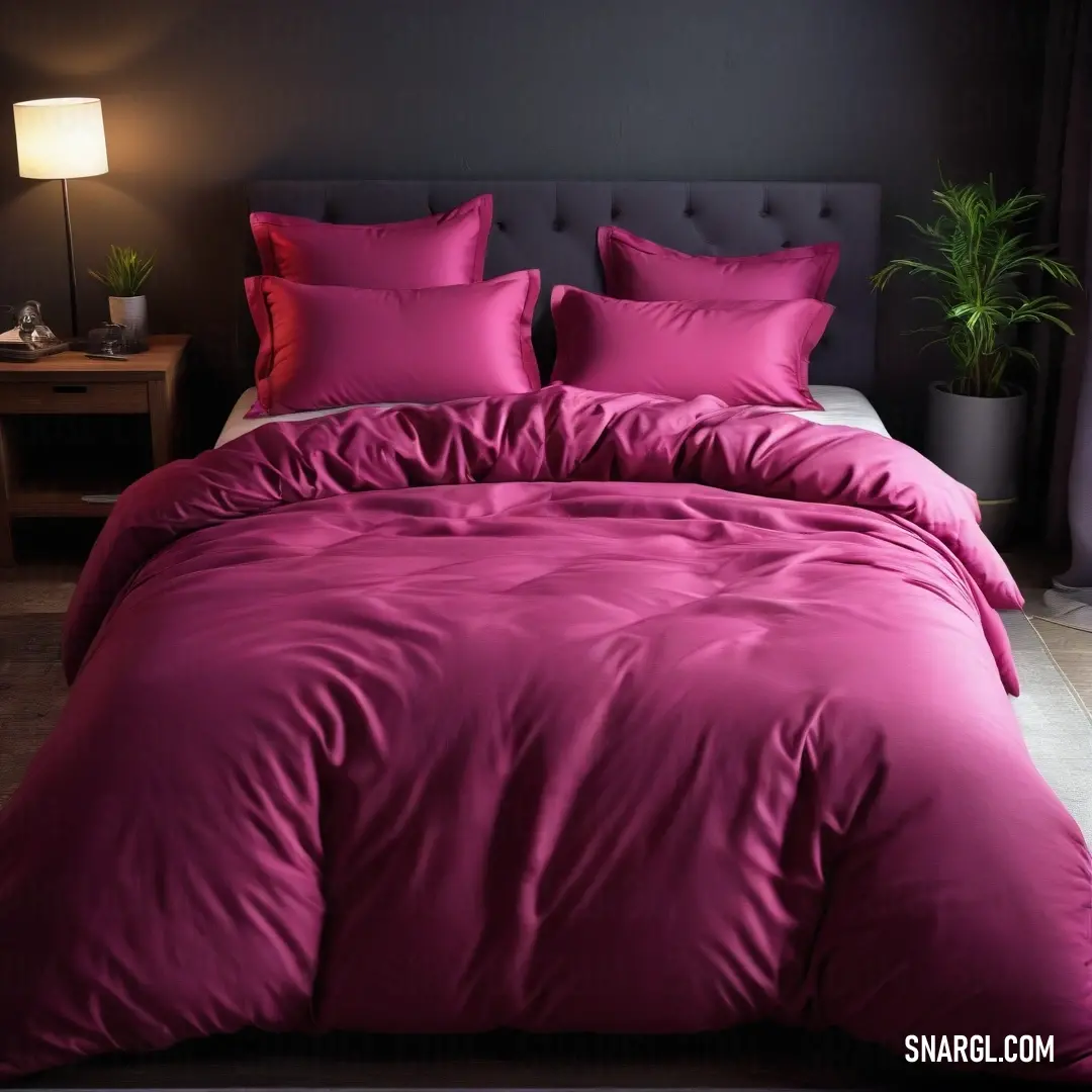 An inviting bedroom features a large bed draped in a soft pink comforter, accented with plush pillows. The space is aglow with a warm lamp and complemented by a luscious plant, embodying tranquility and comfort.