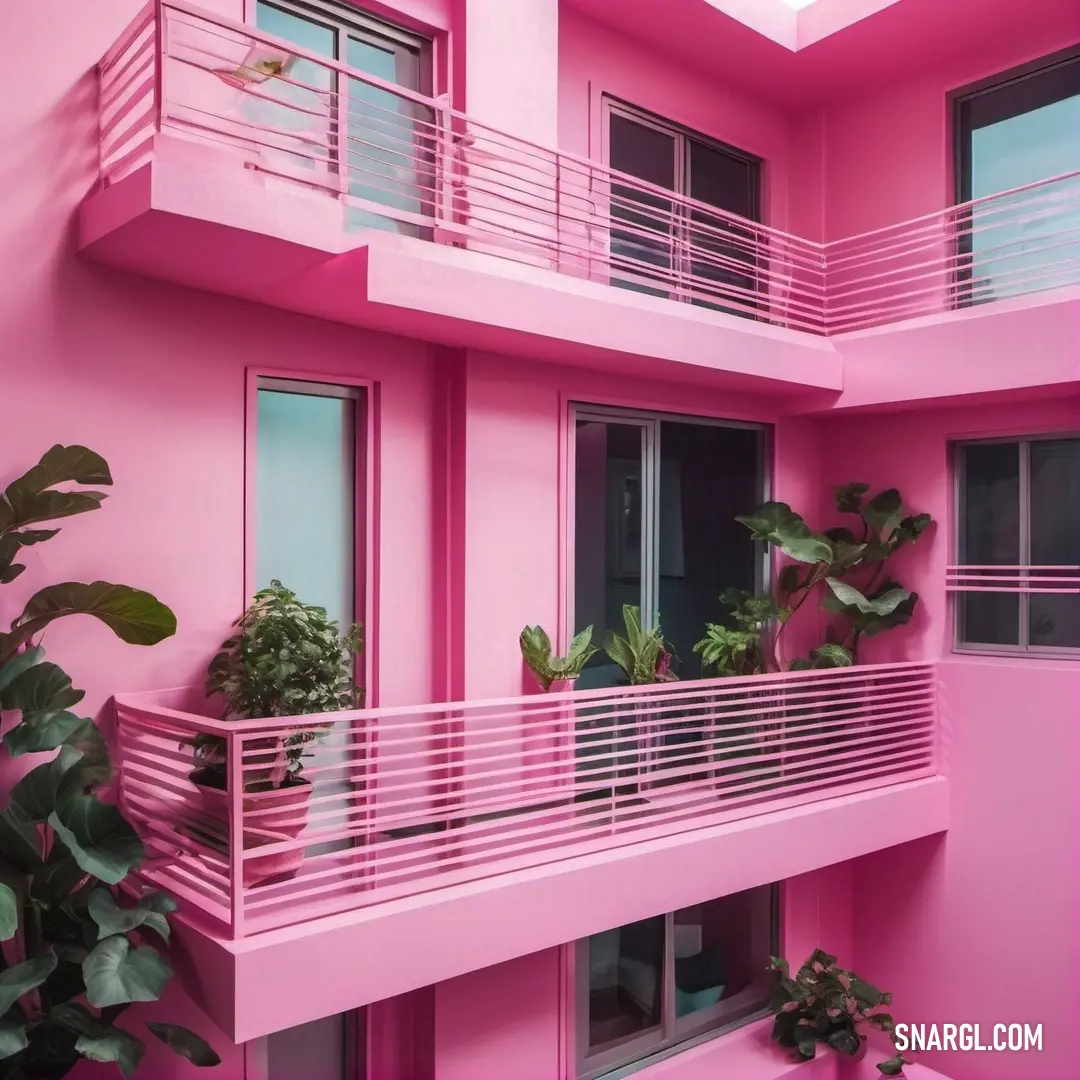 An eye-catching pink building adorned with a charming balcony and vibrant plants, creating an appealing façade that radiates cheerfulness and warmth in its surroundings.