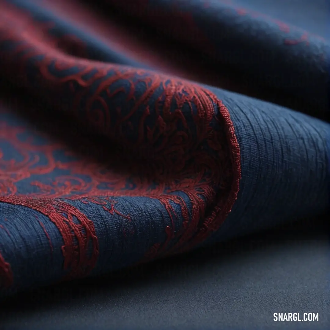 A close-up view of a beautifully interwoven red and blue fabric, inviting touch with its rich textures. The fabric embodies the vibrant spirit of PANTONE Violet, creating an impressive visual experience that intrigues the senses.