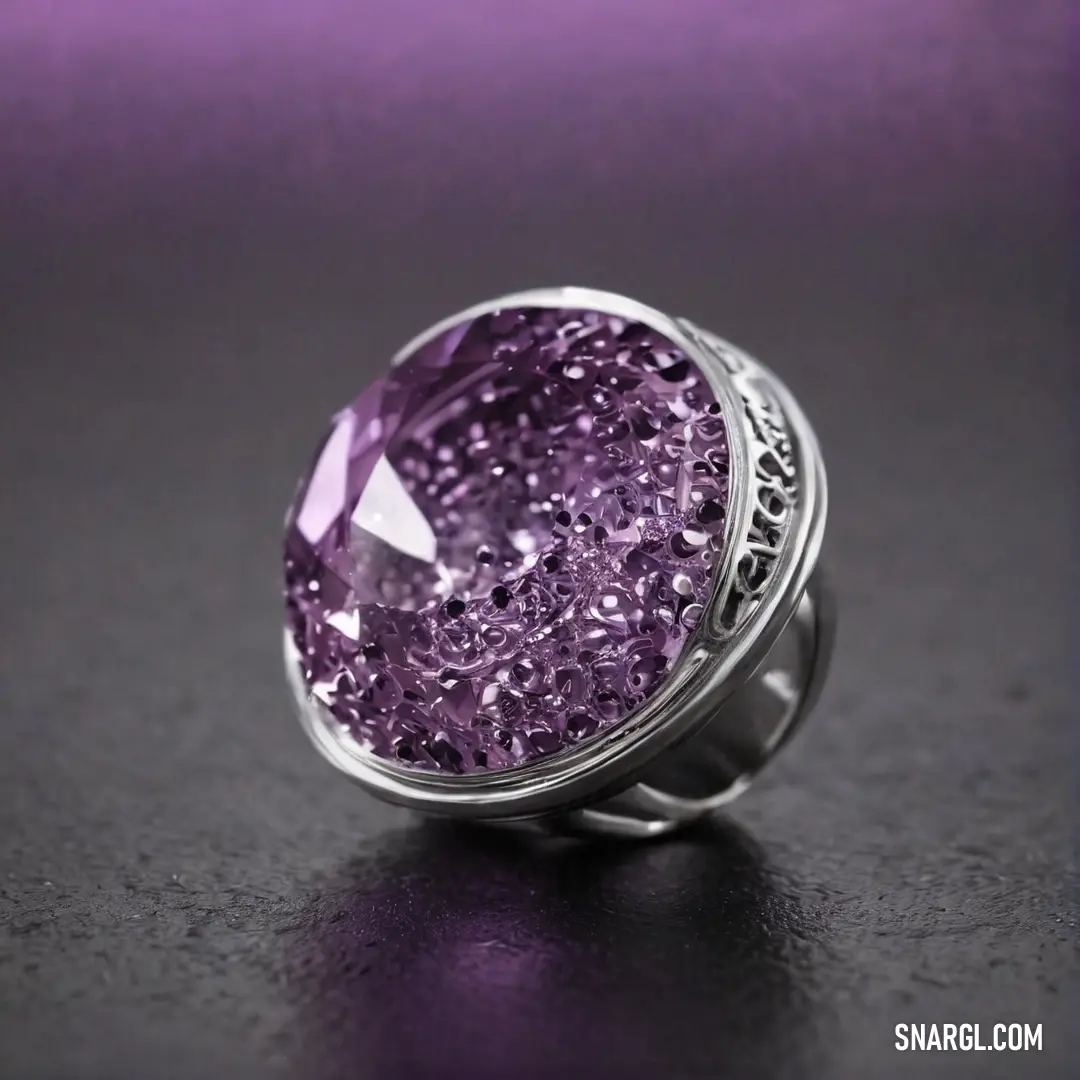 A stunning ring featuring a vibrant purple stone set in a polished band, resting on a table with a muted, earthy tone. The rich hue of the stone stands out against the warm, soft background, creating a sense of quiet luxury.