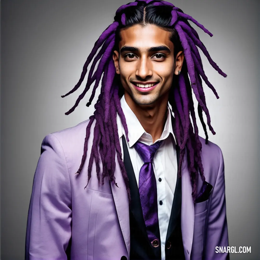 Man with dreadlocks in a purple suit and tie smiling at the camera with a smile on his face