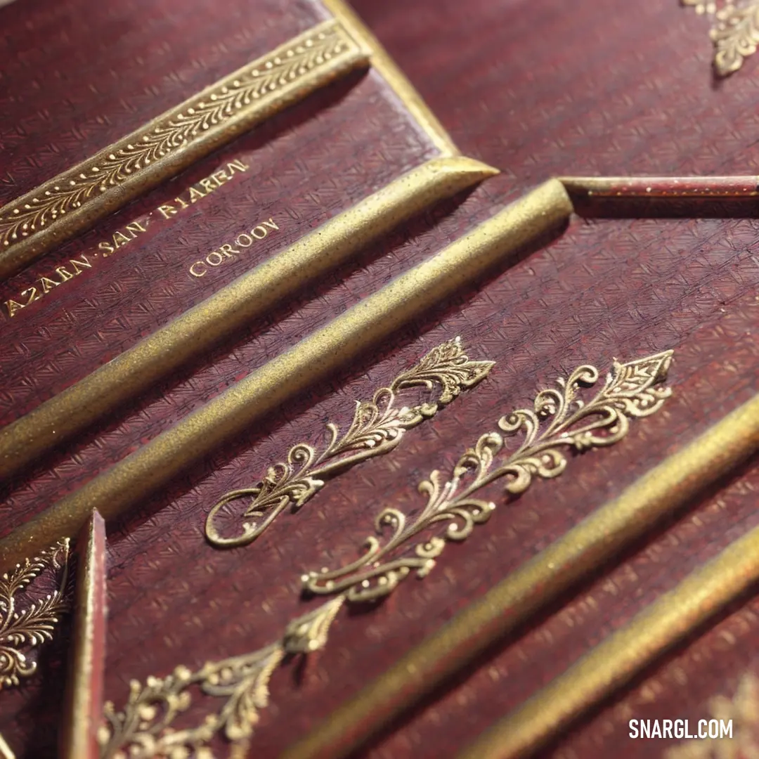 A close-up of a book with intricate gold trimmings on its cover, accompanied by a bookmark. The warm peach-orange hue of the book’s design adds an elegant touch, inviting readers to delve into its contents.