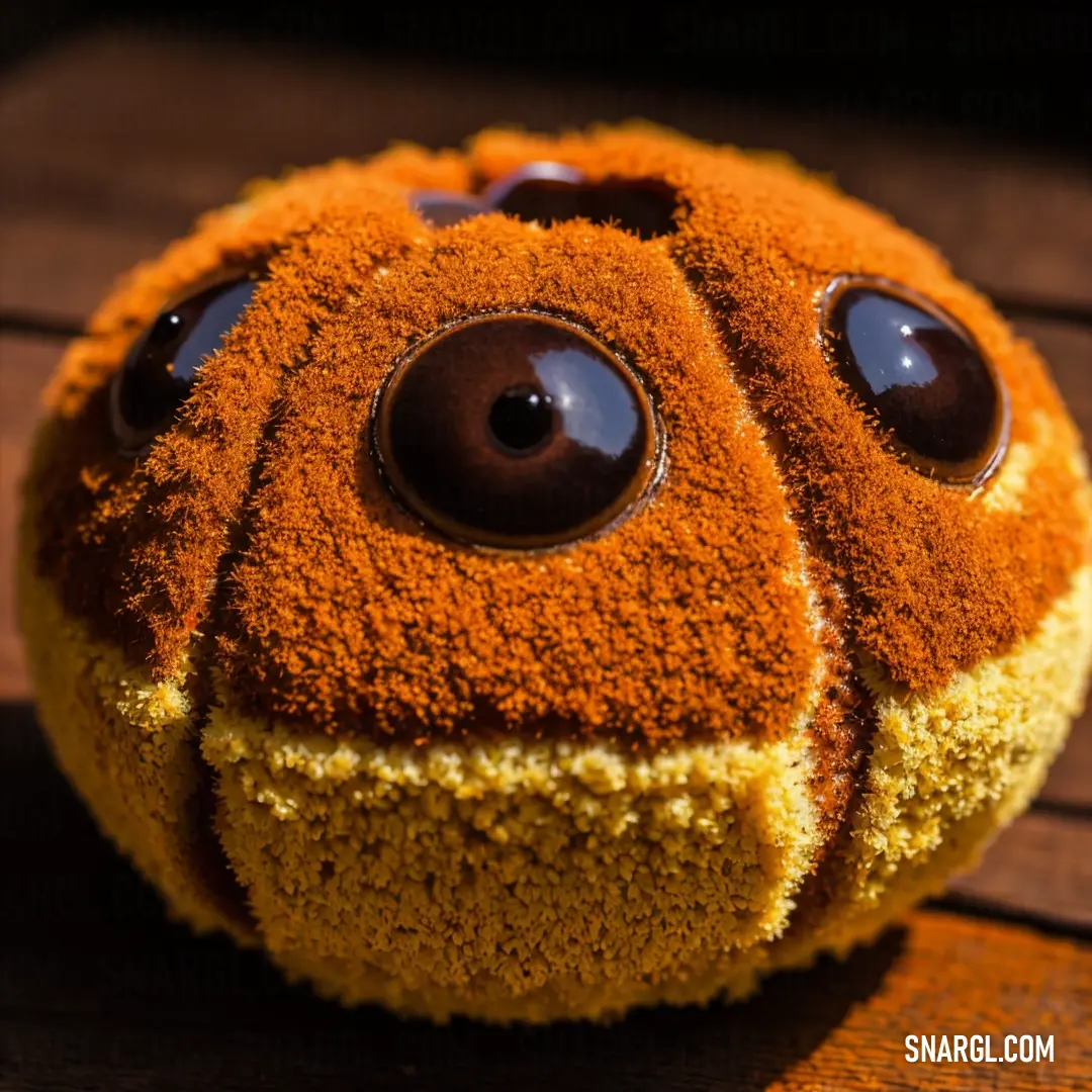 A close-up of a fluffy stuffed animal resting on a smooth wooden surface. The animal's eyes and nose are crafted from brown and yellow powder, evoking the soft, inviting colors of a ripe pear. A perfect blend of texture and warmth.