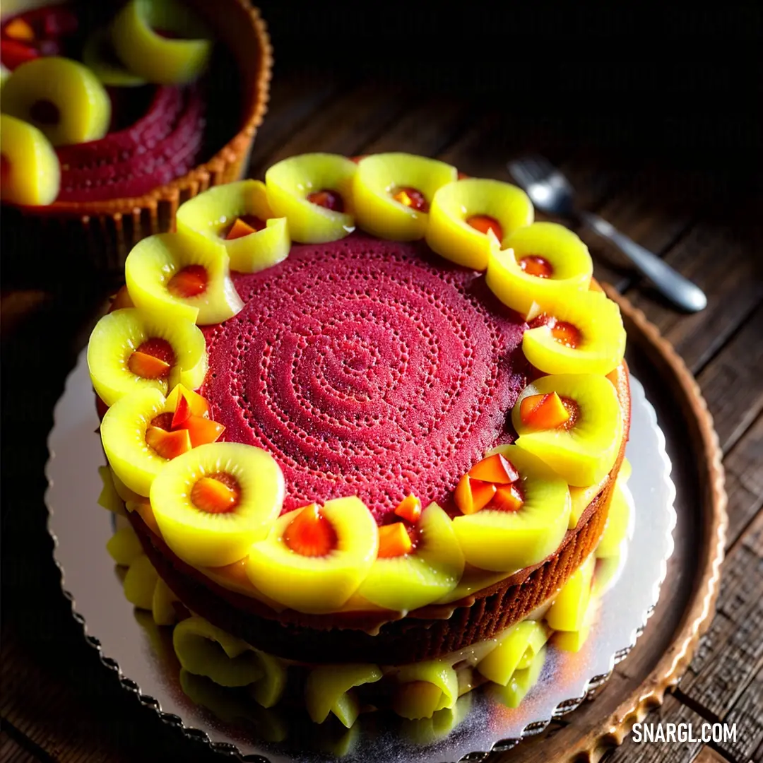 Cake with yellow and red decorations on a plate with a knife and fork next to it on a wooden table