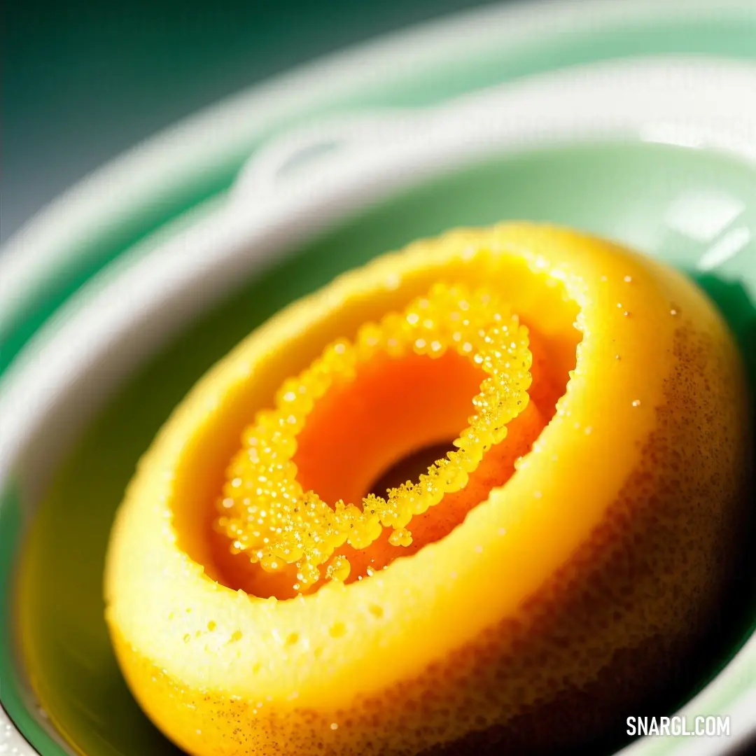 Yellow sponge is in a green bowl on a table top with a white and green rim and a green