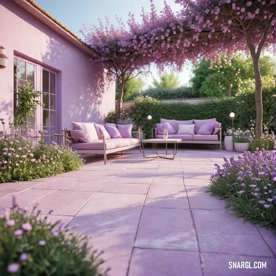 Patio with a couch and table and flowers on the ground and a tree. Example of RGB 204,204,255 color.