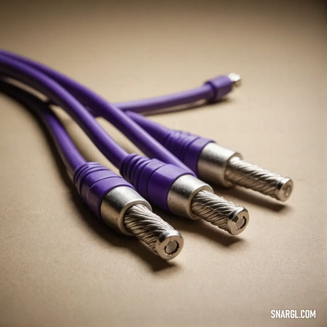 Close up of three purple cables on a table with a black background. Color CMYK 59,85,0,52.