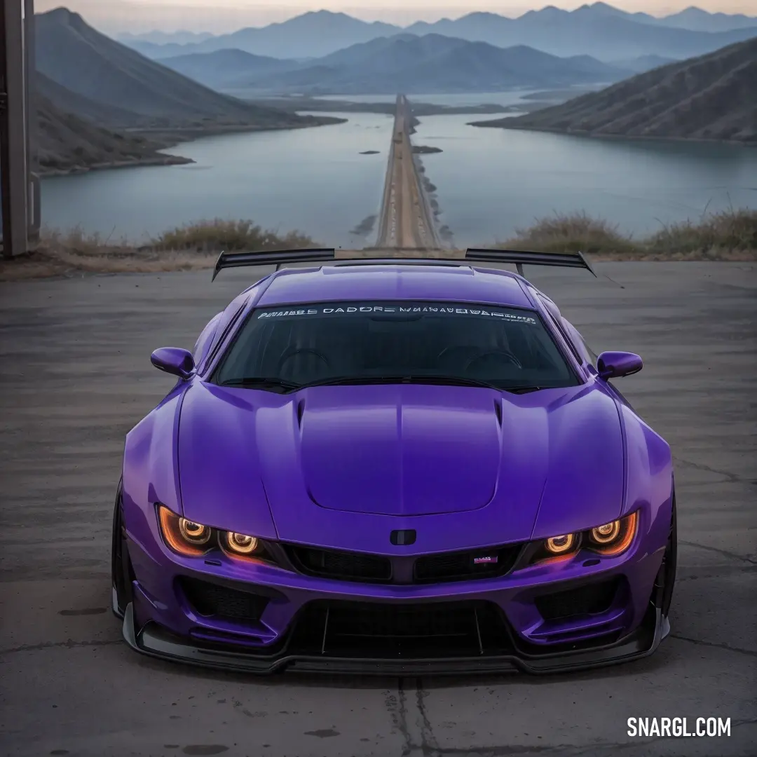 Purple sports car parked on a road next to a lake and mountains in the background. Example of CMYK 59,85,0,52 color.