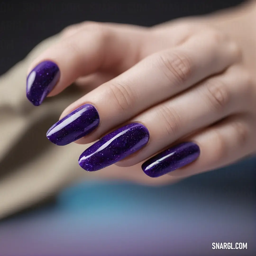 Woman with purple nails holding onto a purple object with a purple ring on it's finger. Color CMYK 59,85,0,52.
