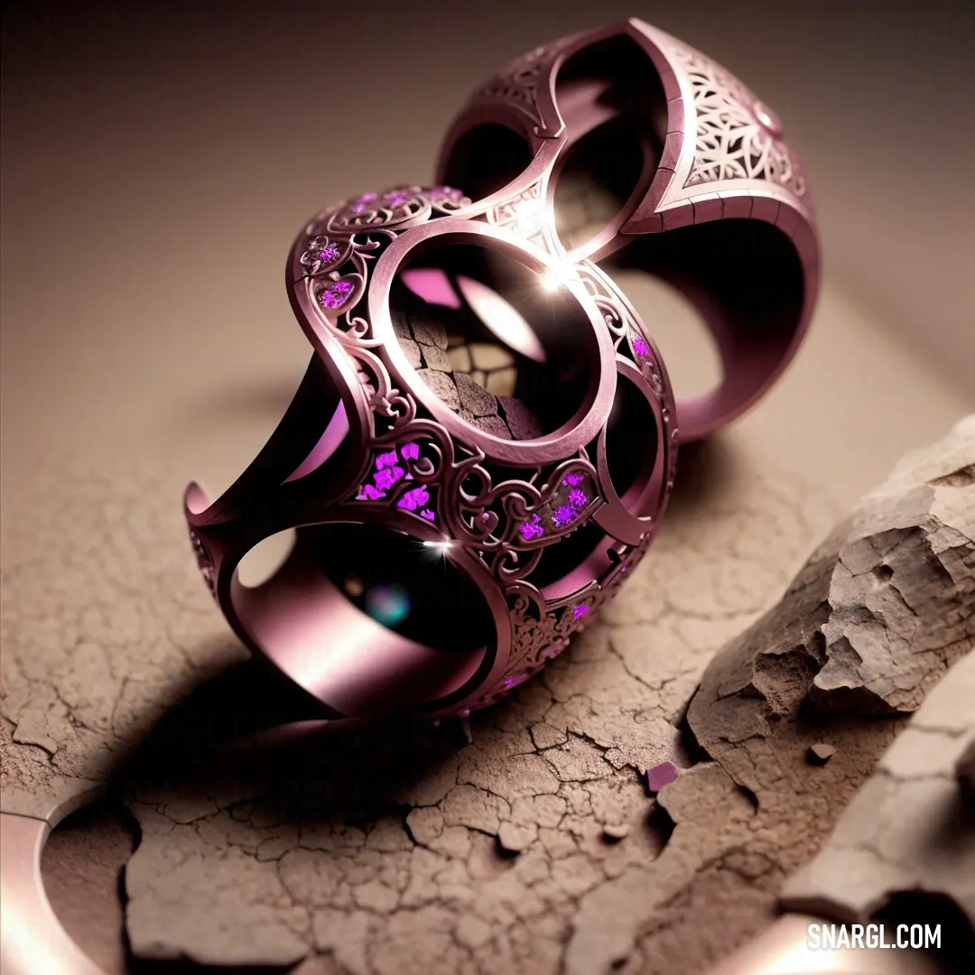 Purple ring with a flower design on it on a cracked surface next to a rock and a piece of wood. Color RGB 252,116,253.