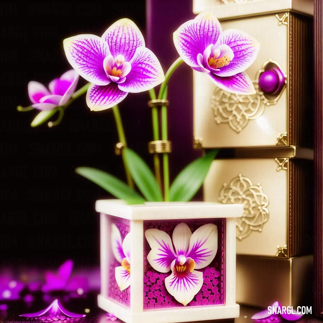 Vase with purple flowers in it on a table next to a box of jewelry