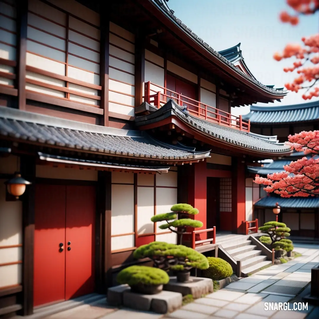 Japanese building with a red door and a tree with red leaves in front of it and a bench