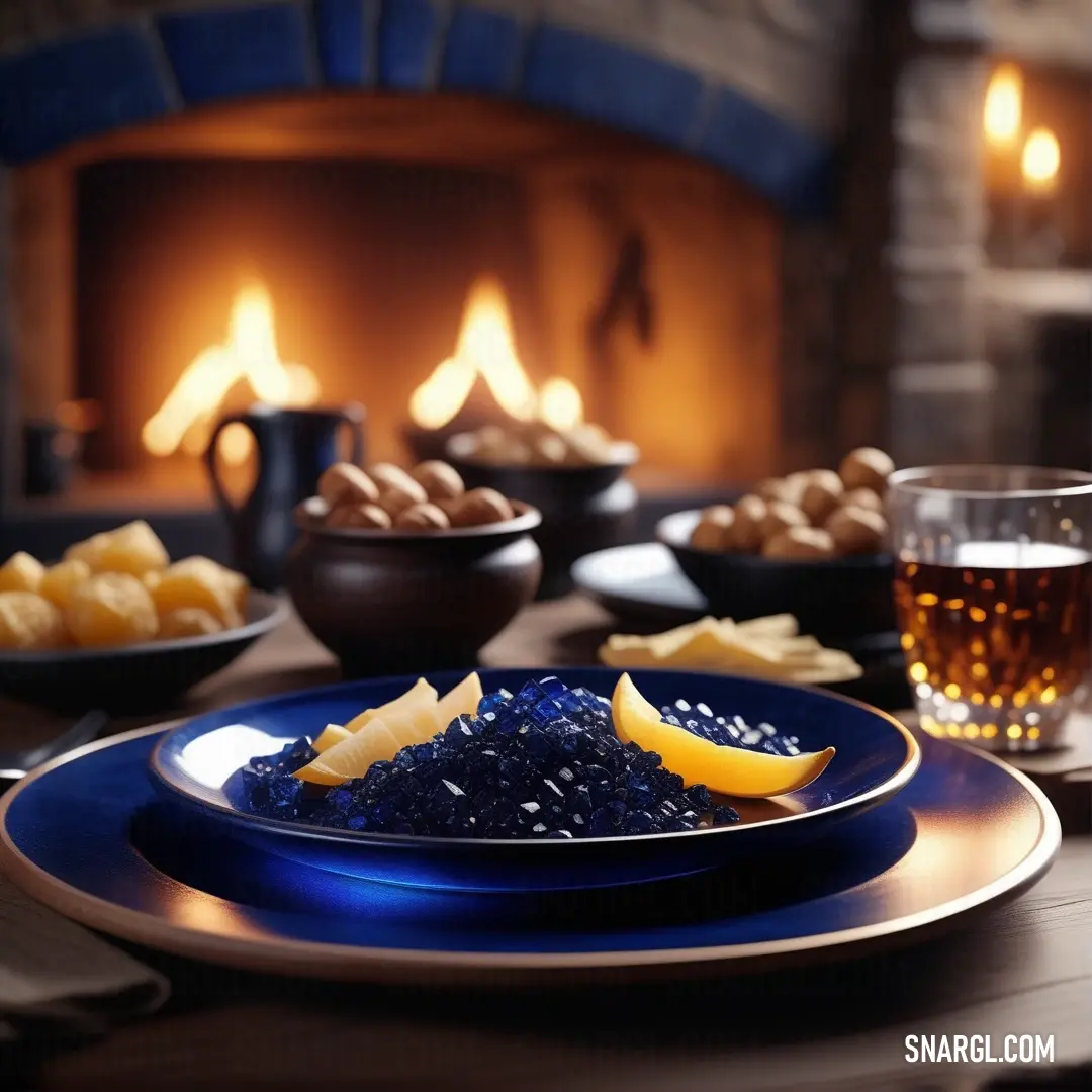 Table with a blue plate and a glass of beer and a fireplace in the background. Color Prussian blue.