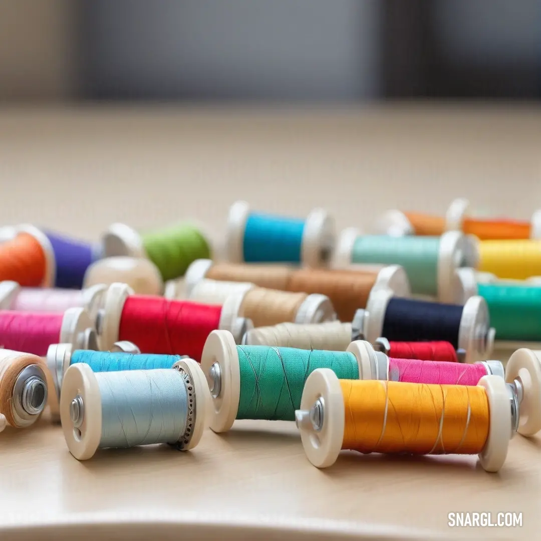 A colorful collection of spools of thread sprawls across a table, each showcasing a distinctive shade, creating a vibrant tableau that ignites inspiration for sewing and crafting enthusiasts.