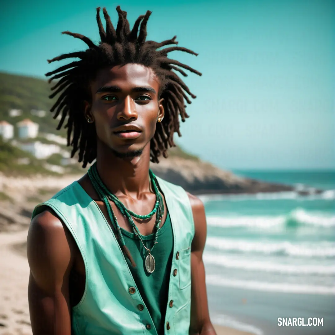 Man with dreadlocks standing on a beach near the ocean with a blue sky in the background. Color RAL 190 50 40.