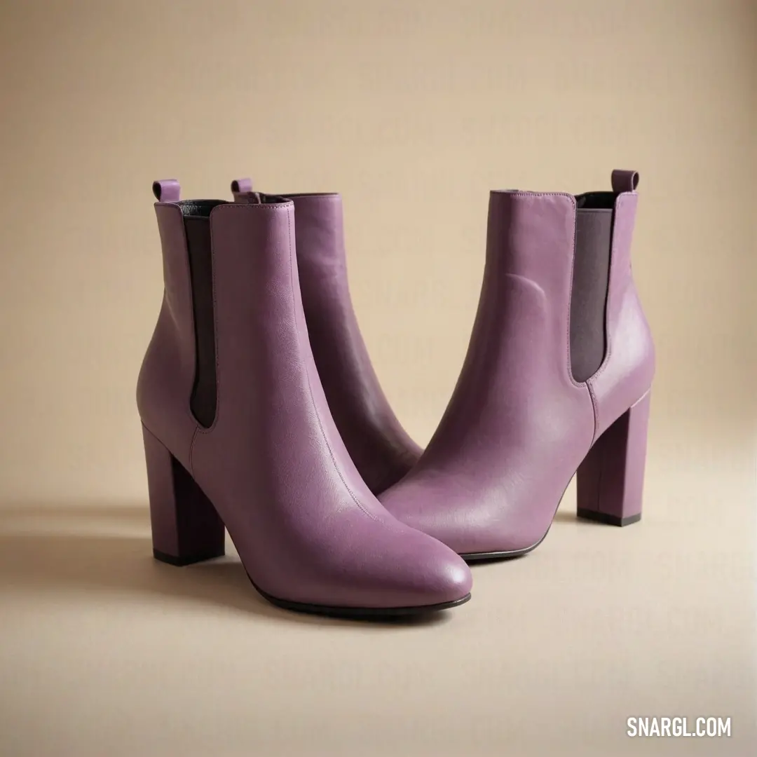 Pair of purple boots with a heel on a beige background. Example of #A587AF color.