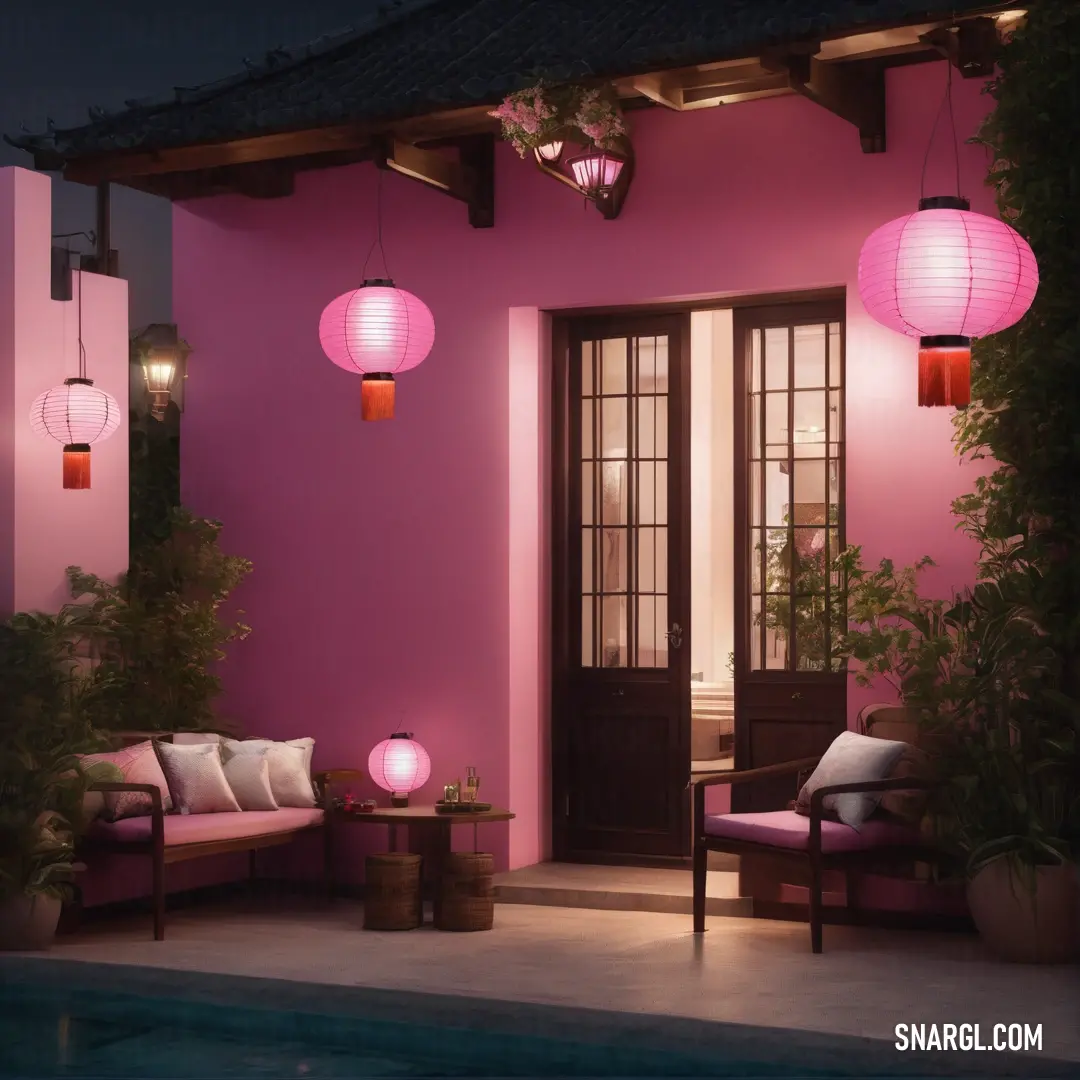 Pink house with a pool and a lit up porch area with a couch and table and lamps on the outside. Example of #F5B5C8 color.