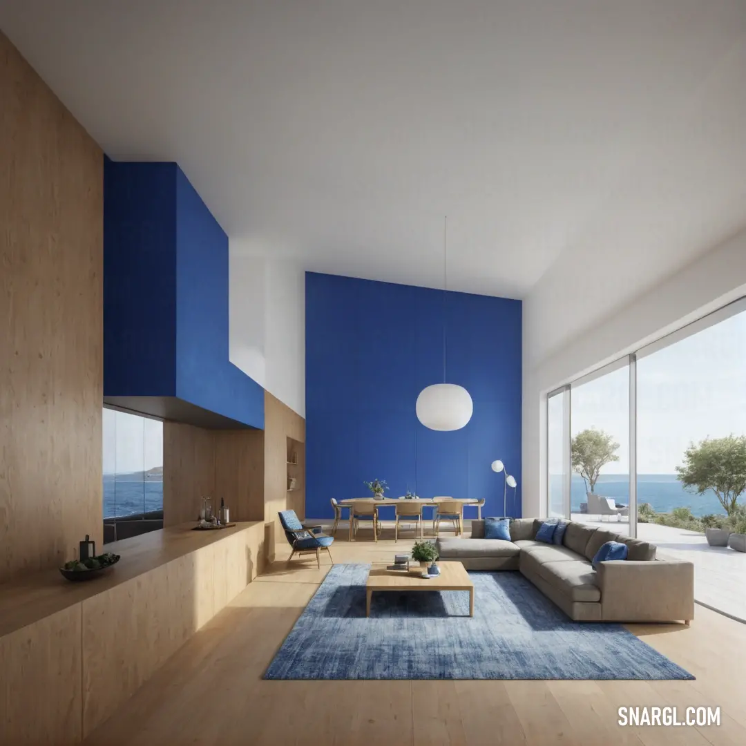 Living room with a blue wall and a large window overlooking the ocean and a couch and table. Color RAL 640-4.